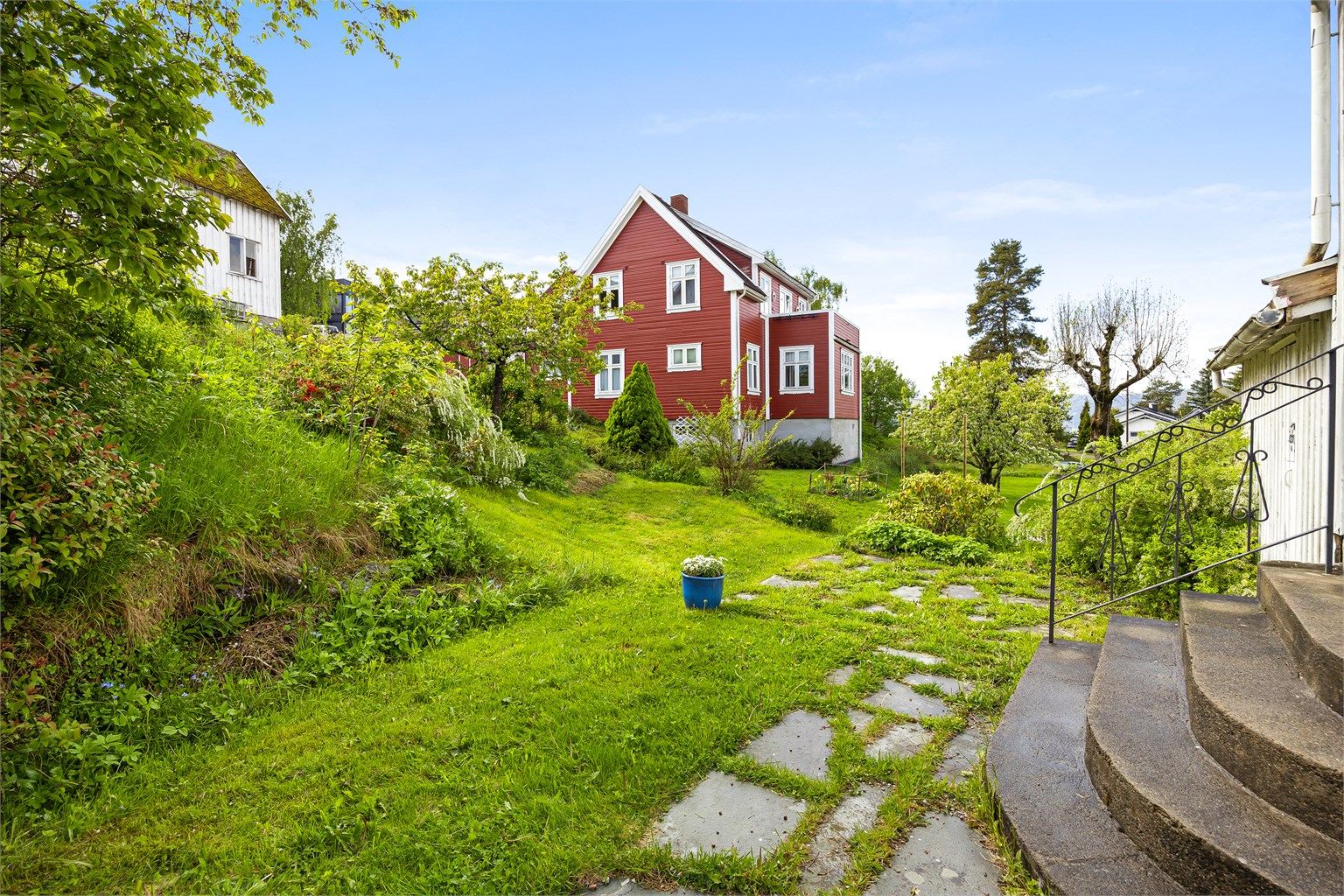 Tomten er opparbeidet med gruset gårdsplass/innkjørsel og plenarealer.