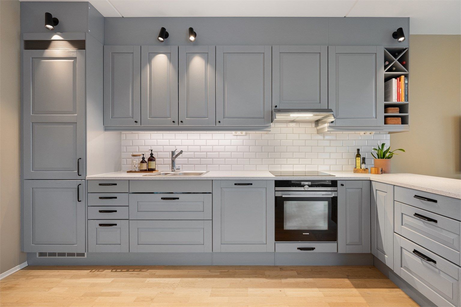 Strøkent kjøkken med åpen og sosial løsning mot stue. Kvalitetsrik kjøkkeninnredning fra Sigdal med profilerte fronter og påkostet lekker Corian benk. Nyere koketopp, komfyrvakt og ventilator. Fliser mellom kjøkkenbenk og overskap