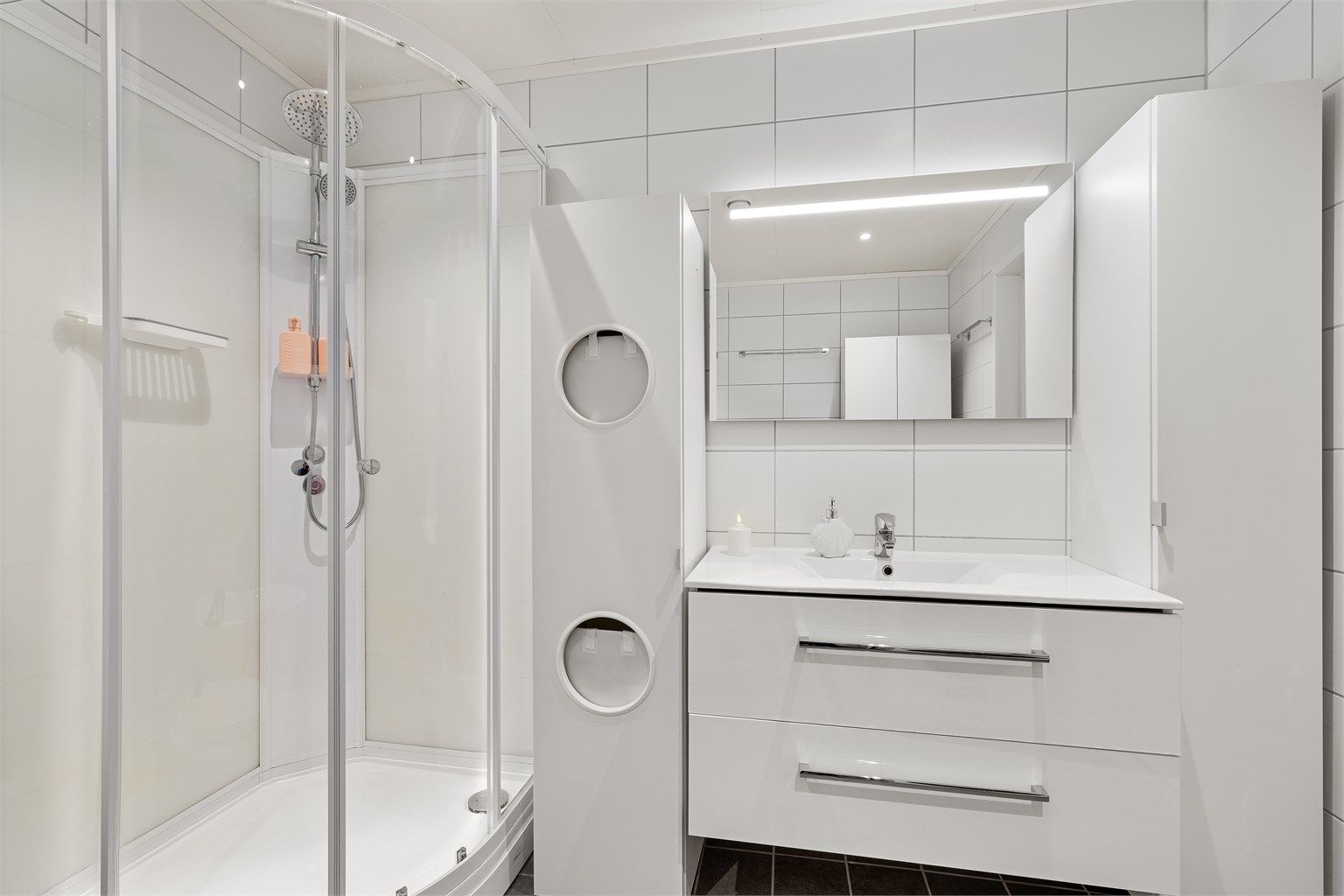 Baderomsmøbler med fin lagringsplass og speil med lys. Skittetøyskap til venstre for vask og høyskap til høyre for vask følger ikke boligen.