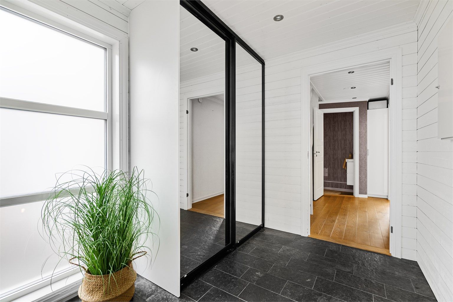 Det er skyvedørsgarderobe med speilfronter, og god oppbevaringsplass. 
