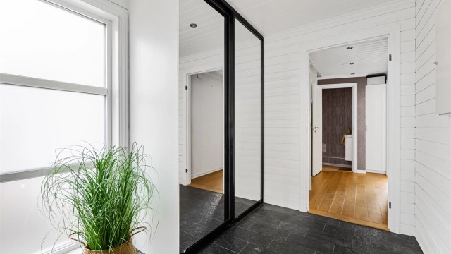 Det er skyvedørsgarderobe med speilfronter, og god oppbevaringsplass.