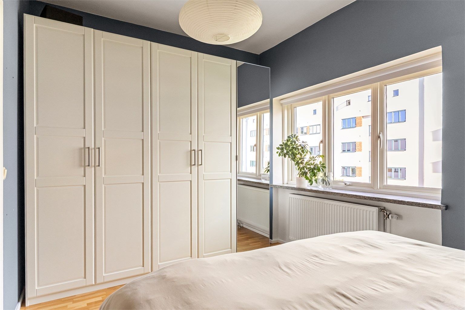 Rikelig med oppbevaringsplass i en hel garderoberekke langs veggen. Store vinduer slipper inn morgenlyset og gir rommet en luftig følelse.