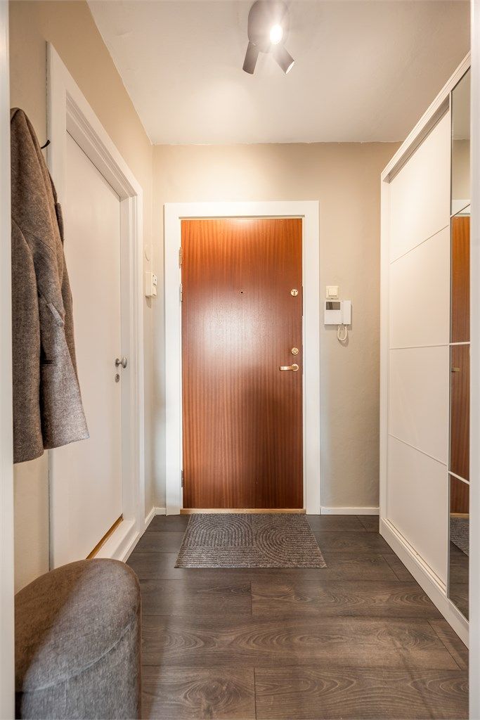 Entréen har callinganlegg og god plass til oppbevaring i garderobeskap med speildører. Badet er inn døren til venstre.