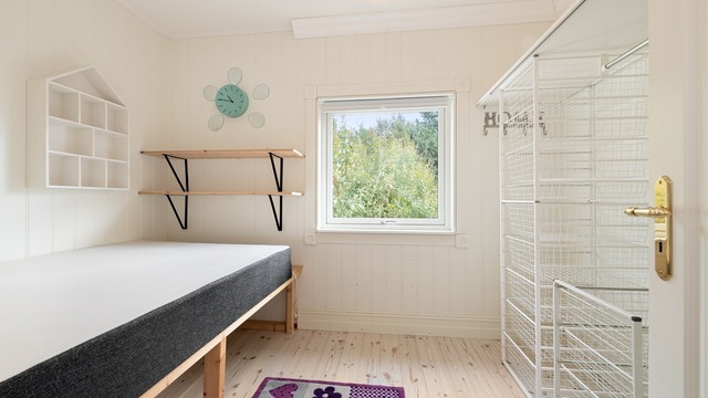 Soverom nr. 2 i hovedetasjen med åpen garderobeinnredning med trådkurver