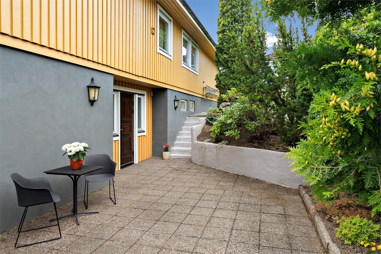 I tilknytning til boligens inngangsparti er det hellelagt markterrasse.