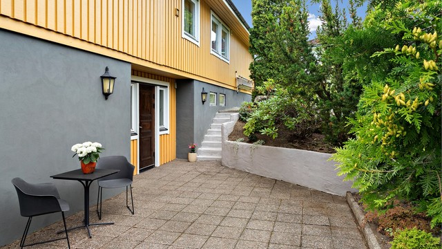 I tilknytning til boligens inngangsparti er det hellelagt markterrasse.