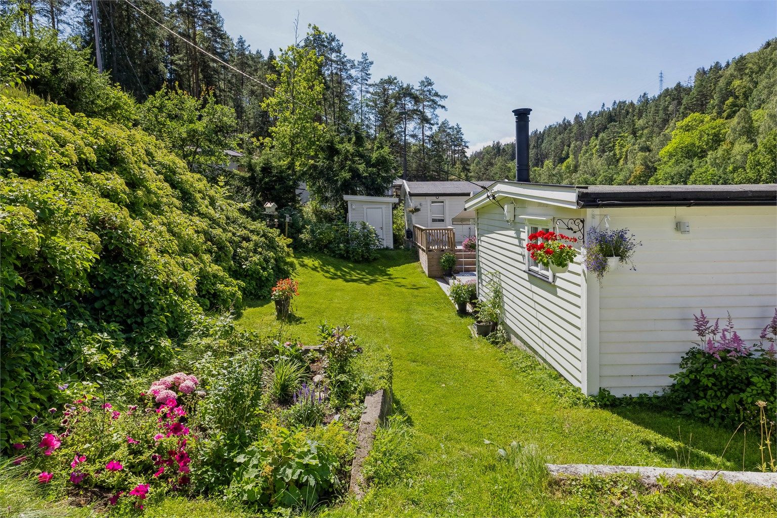 Stor og pent opparbeidet eiendom med frodig hage og vakre beplantninger