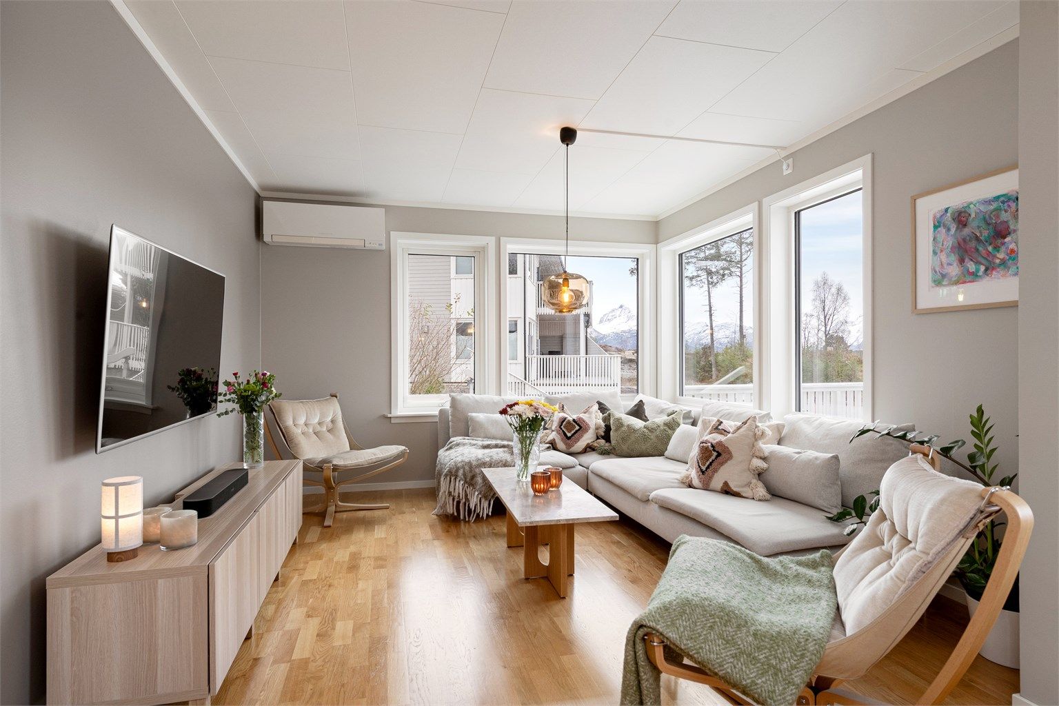 Her i stuen sørger en varmepumpe for jevn temperatur, mens utsikten mot Sunnmørsalpene rammes inn av store vindusflater.