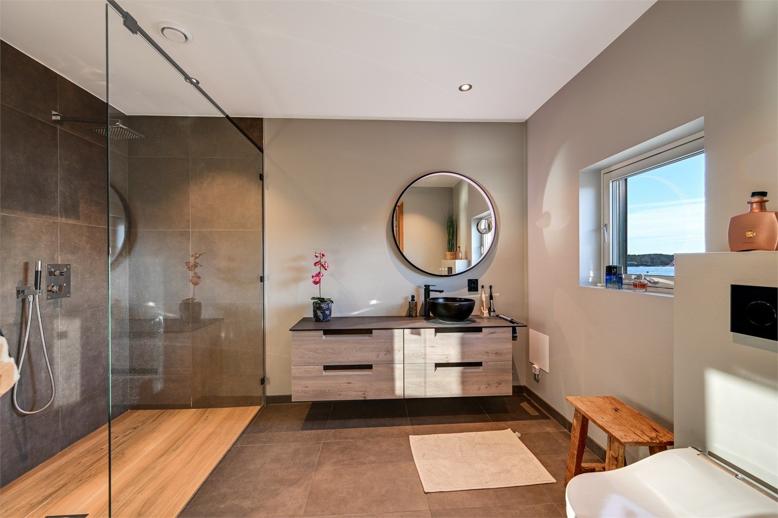 Privat bad tilligende hovedsoverommet. Badet har fliser på veggene i dusjsonen og våtromstapet med malt overflate på øvrige veggoverflater. 