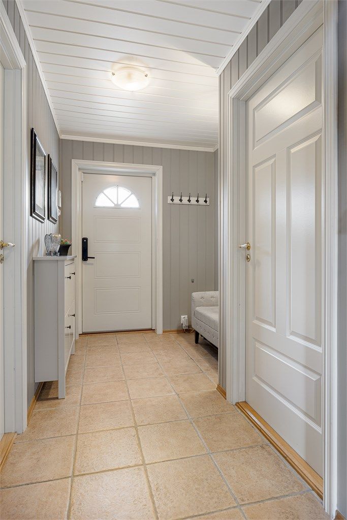 Fra gangen er det adkomst til bad, to soverom og stuen. Vegger og himling har panel, som er gjennomgående i store deler av boligen.