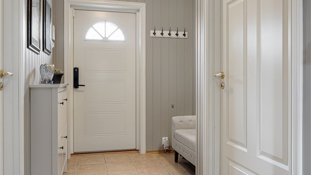 Fra gangen er det adkomst til bad, to soverom og stuen. Vegger og himling har panel, som er gjennomgående i store deler av boligen.