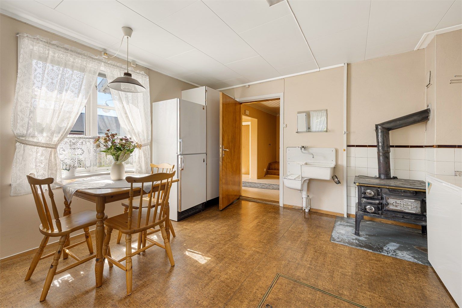Kjøkkenet har plass til spisebord og er utstyrt med en sjarmerende vedovn.