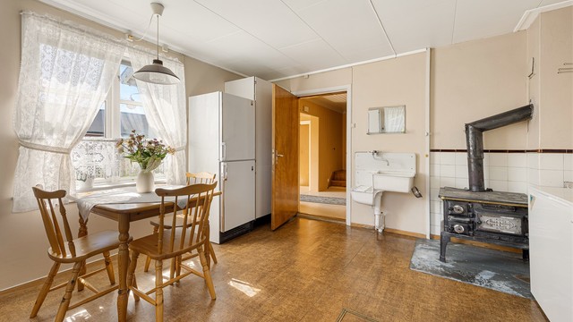 Kjøkkenet har plass til spisebord og er utstyrt med en sjarmerende vedovn.