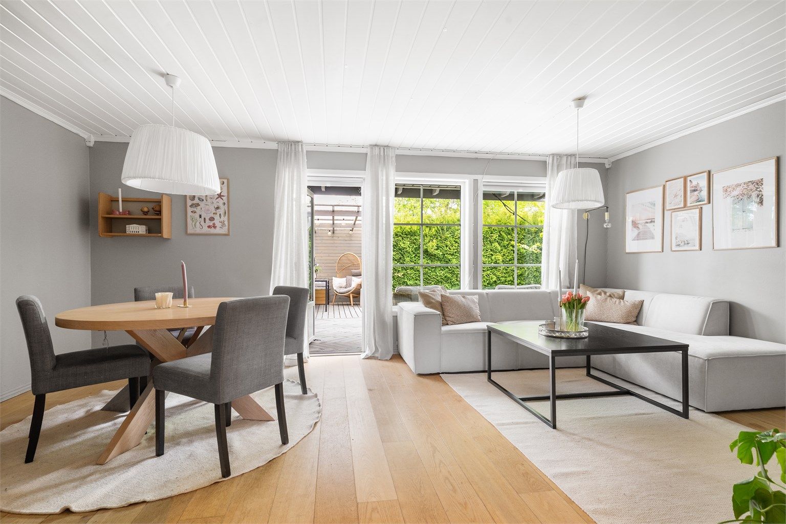 Stuen har plass til både sofagruppe og spisebord, med direkte utgang til uteplassen.