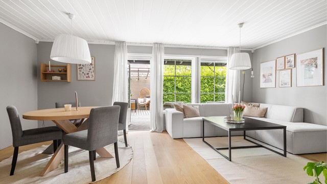 Stuen har plass til både sofagruppe og spisebord, med direkte utgang til uteplassen.