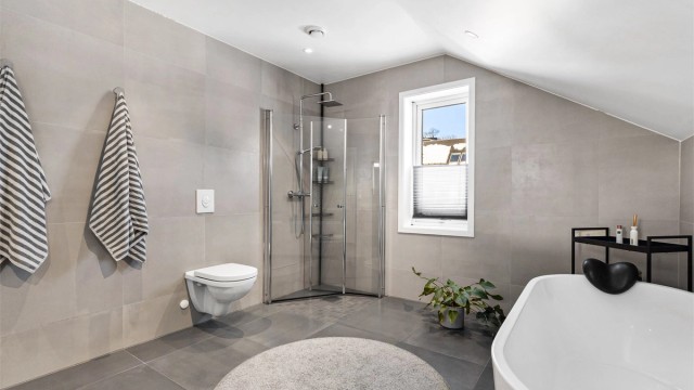 Dusjhjørne med dører. Vegghengt dusjarmatur. Mekanisk avtrekk med ventil i himling. Luftespalte for overstrømning under dør.