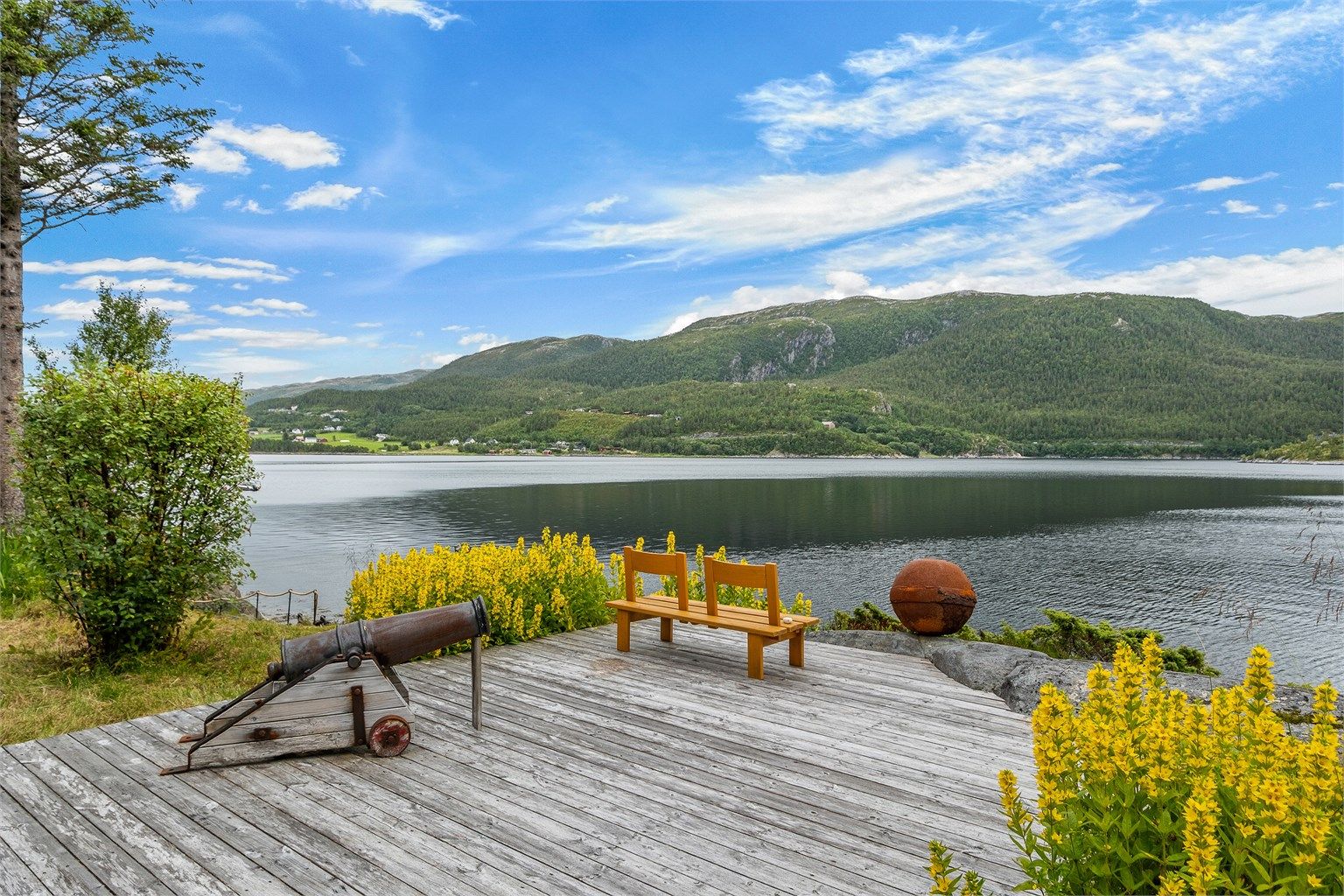 En flott utsiktsplass helt nede mot sjøen, hvor fjorden og fjellandskapet danner et imponerende bakteppe.