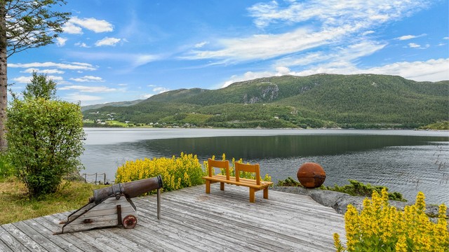 En flott utsiktsplass helt nede mot sjøen, hvor fjorden og fjellandskapet danner et imponerende bakteppe.