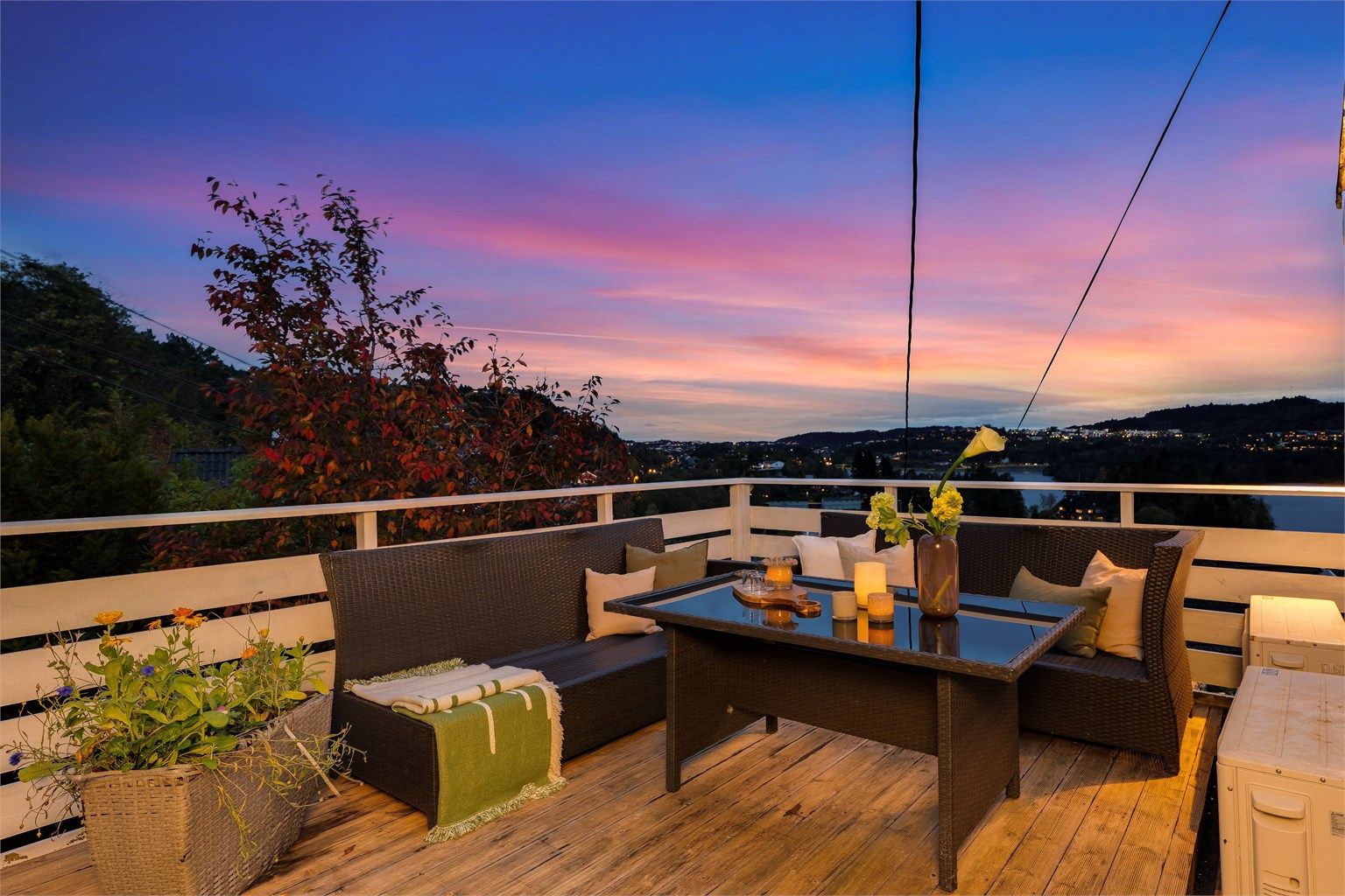 Romslig terrasse med terrassebord, belysning og god plass til utemøbler.