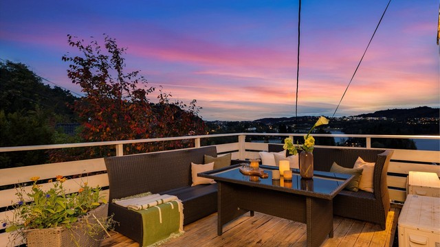 Romslig terrasse med terrassebord, belysning og god plass til utemøbler.