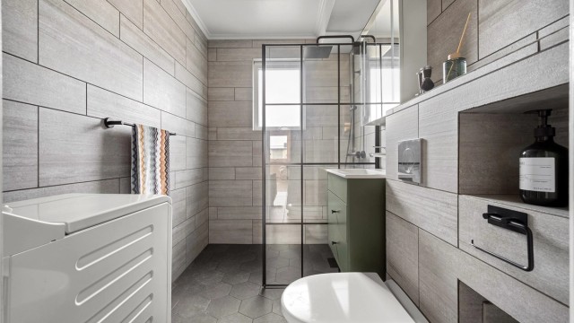 Badet ble rehabilitert i 2021 og har flislagte overflater, gulvvarme og opplegg for vaskemaskin.