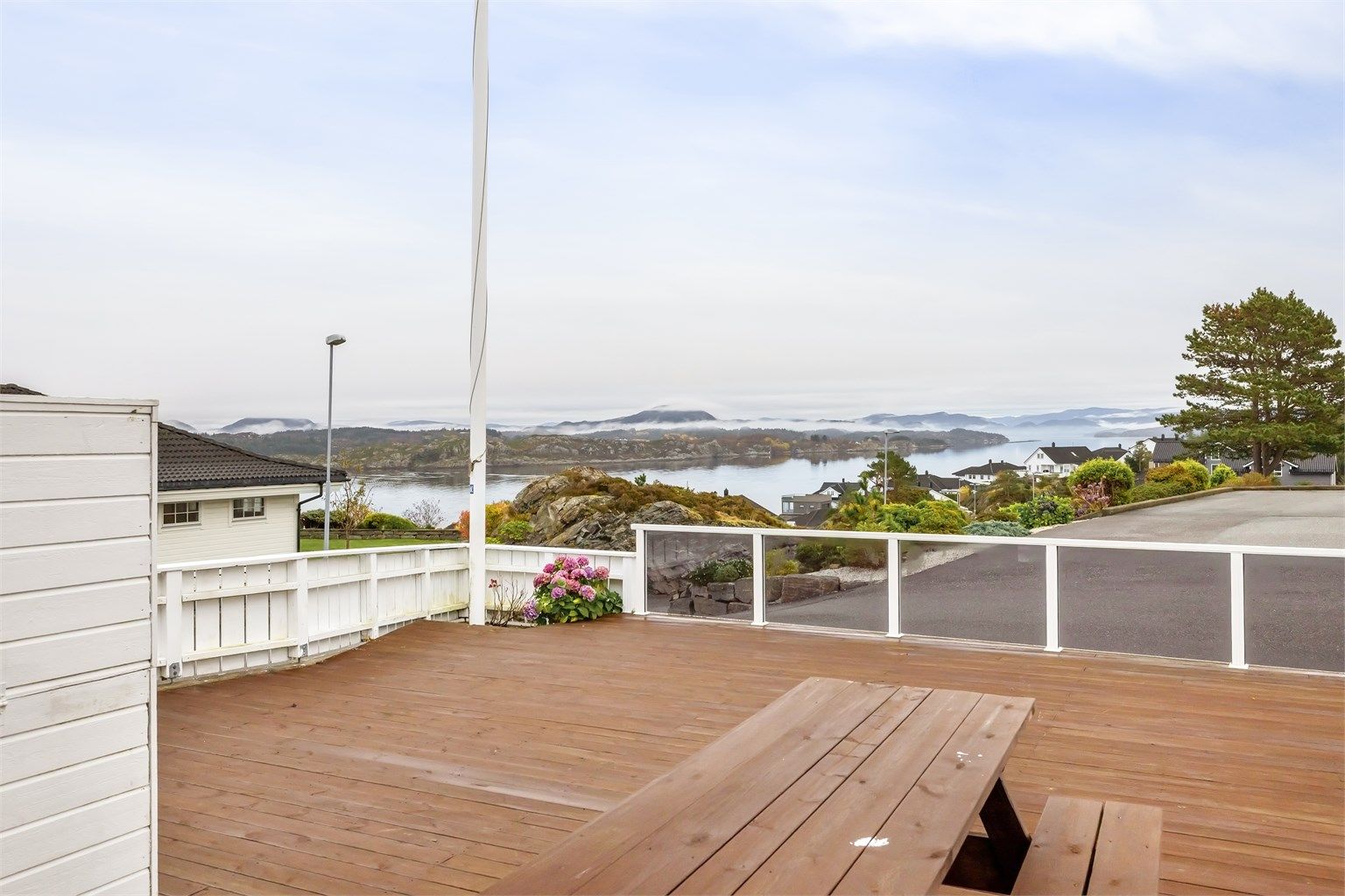 Solrik stor terrasse i nydelige omgivelser. Rålekker utsikt mot sjø og landskap.