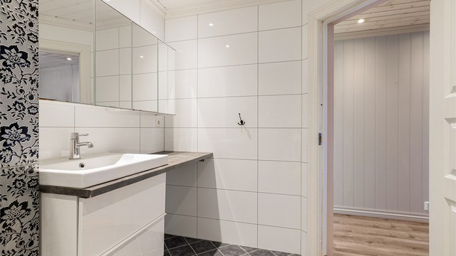 Badet er utstyrt med servant i seksjon med speil over, dusjkabinett, wc og opplegg til vaskemaskin.