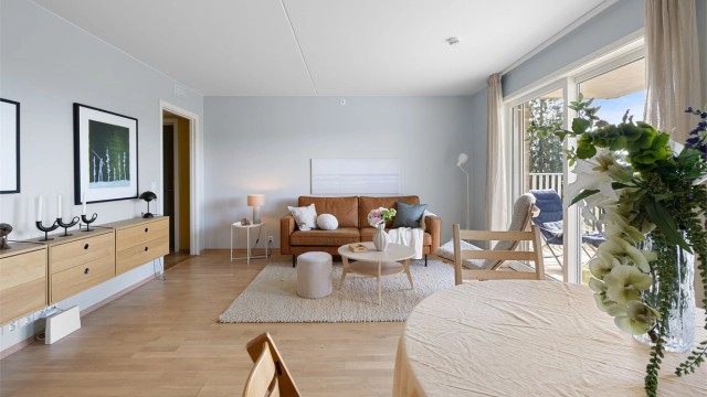 Den romslige stuen har en åpen og innbydende atmosfære med god plass til både sofagruppe og spisebord.