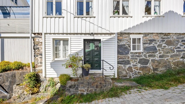 Enebolig fra ca. 1860 med laftet tømmerkonstruksjon og tradisjonell, stående tømmermannskledning.