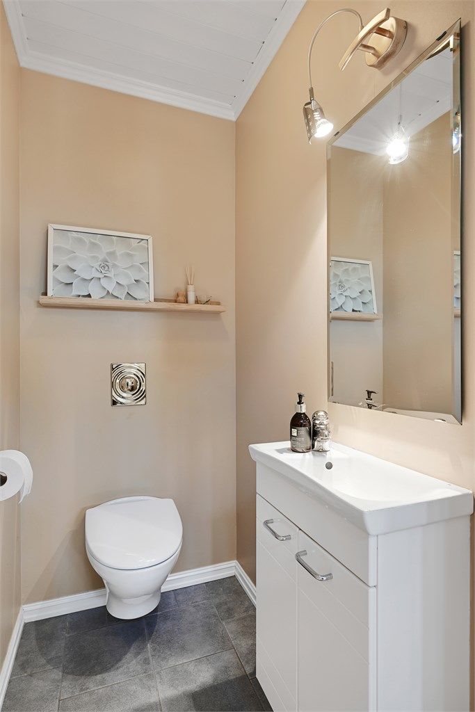 Praktisk toalettrom i første etasje, med vegghengt toalett installert i 2022.