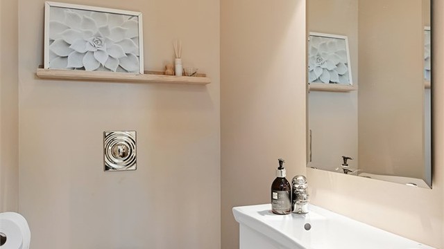 Praktisk toalettrom i første etasje, med vegghengt toalett installert i 2022.