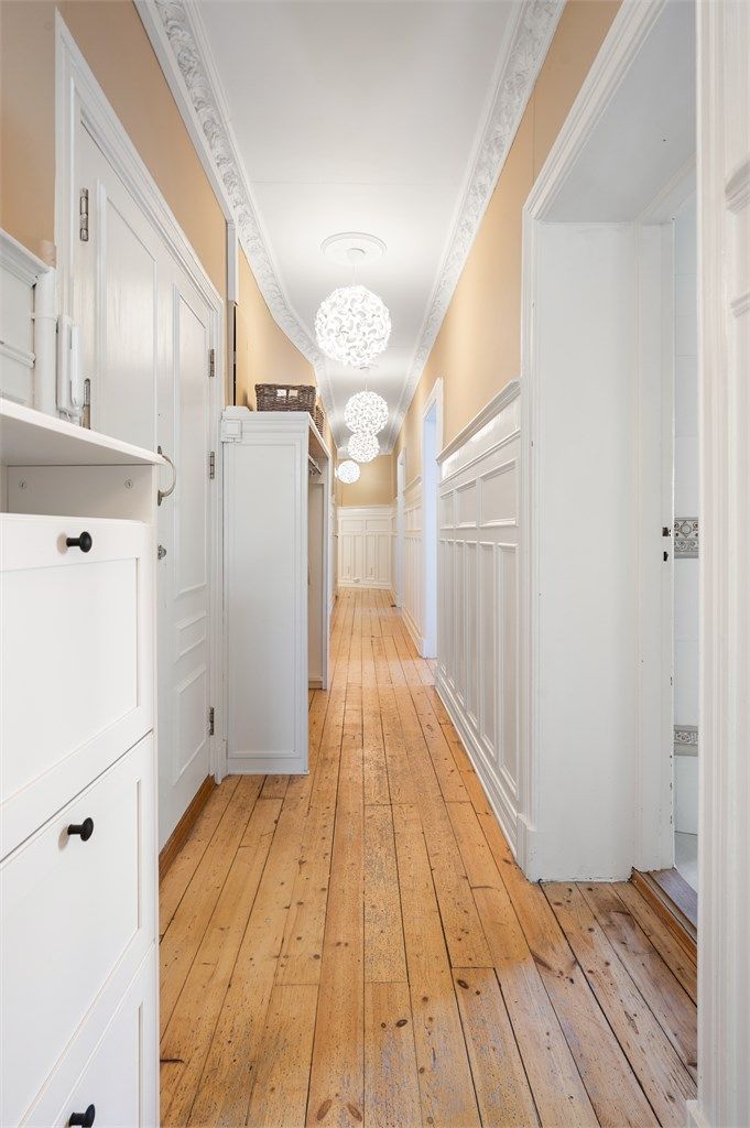 Entréen er romslig og gir et godt førsteinntrykk av leiligheten. Her er det rom for å henge fra seg yttertøy og sko i praktisk garderobe. Innvendig trapp ned til underetasjen