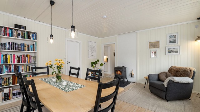 Stuen har tregulv og en koselig peisovn som skaper hygge og god varme i rommet