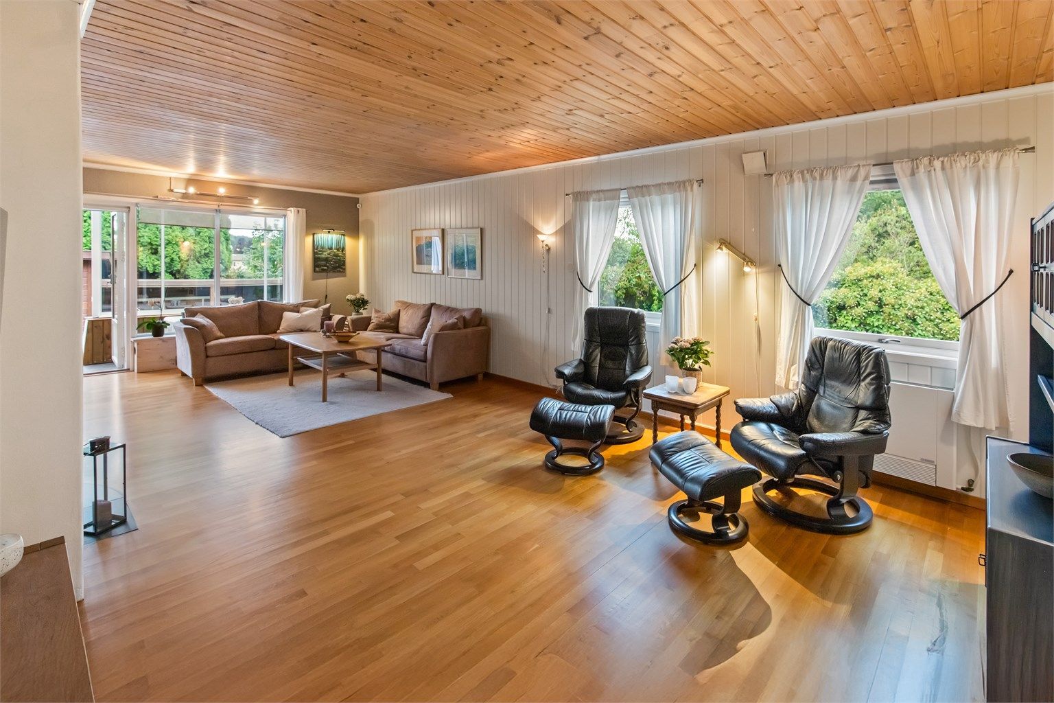 Meget romslig stue med parkett på gulv.