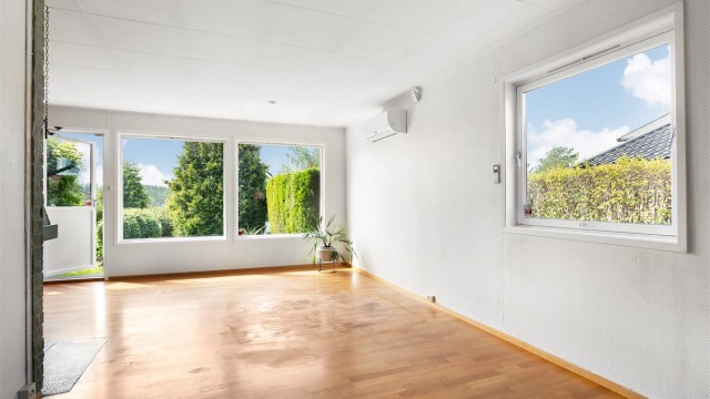 Store vindusflater gir godt med dagslys og utsyn mot hagen.