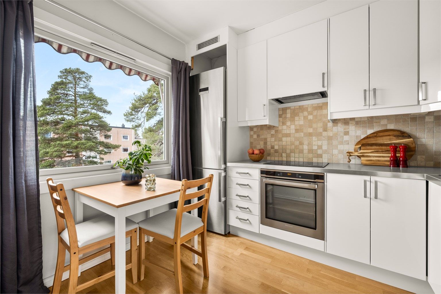 Ventilator med kullfilter er plassert i overskapet, og varmtvannsberederen er plassert i benkeskap.