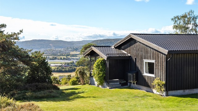 Boligen ligger høyt og fritt på tomten med utsikt.