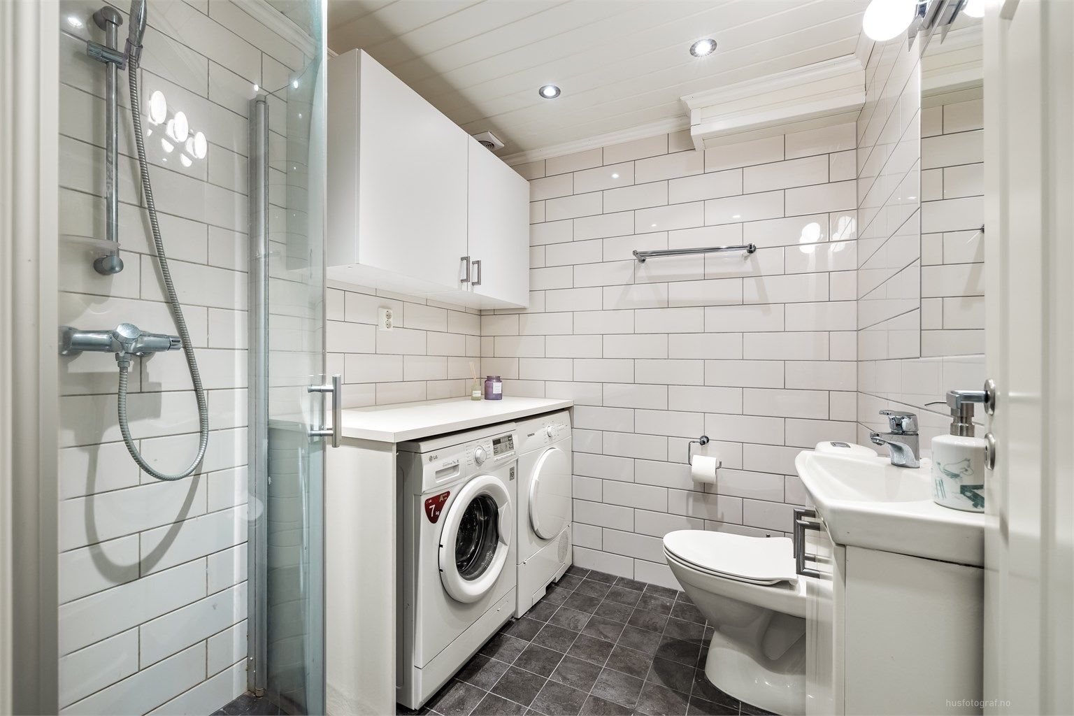 Rommet er praktisk innredet med dusjhjørne og opplegg for vaskemaskin samt tørketrommel.