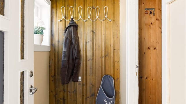 Entréen har plass til oppheng av yttertøy på panelkledd vegg.