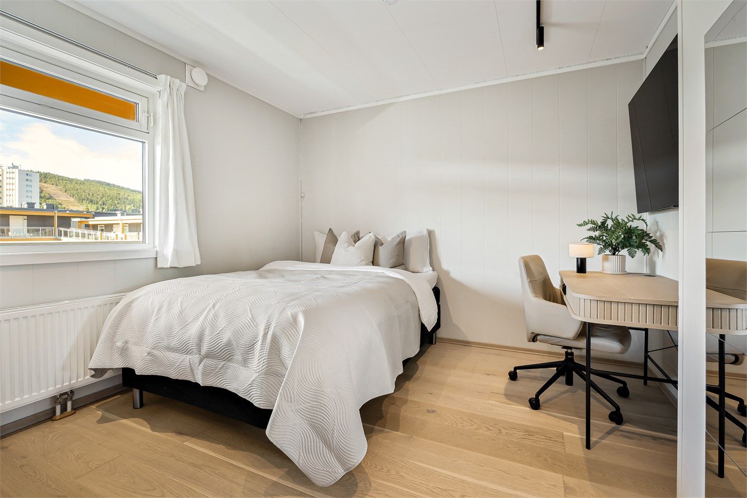 Leiligheten har et soverom med plass til seng og skrivebord.