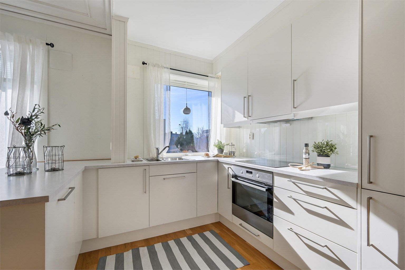 Kjøkkenet har lyse glatte fronter og benkeplate av laminat.