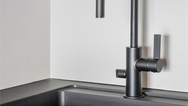 Kjøkkenet er utstyrt med innredning med mørke glatte fronter, benkeplate i laminat med nedfelt oppvaskkum med blandebatteri.