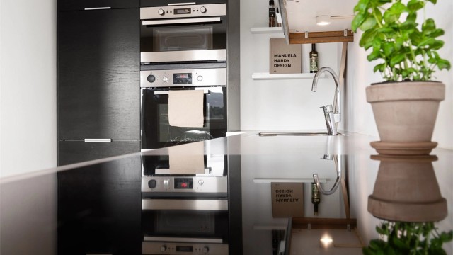 Integrert stekeovn og mikrobølgeovn i praktisk arbeidshøyde. Benkeplaten er i slitesterk laminat.