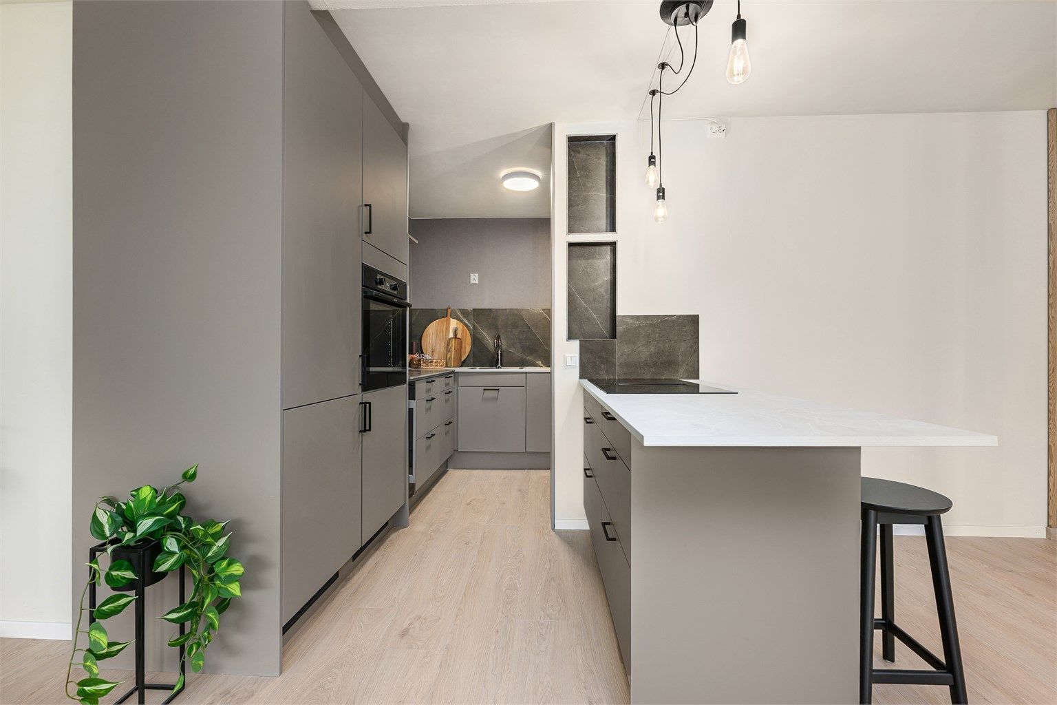 Stilrent kjøkken fra 2025 med integrerte hvitevarer og en sosial, åpen løsning mot stuen.