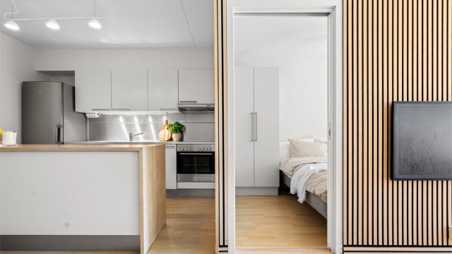 Inngang fra stuen til soverom med skyvedører som gir et luftig særpreg til rommet og slipper inn rikelig med naturlig lys til leiligheten.