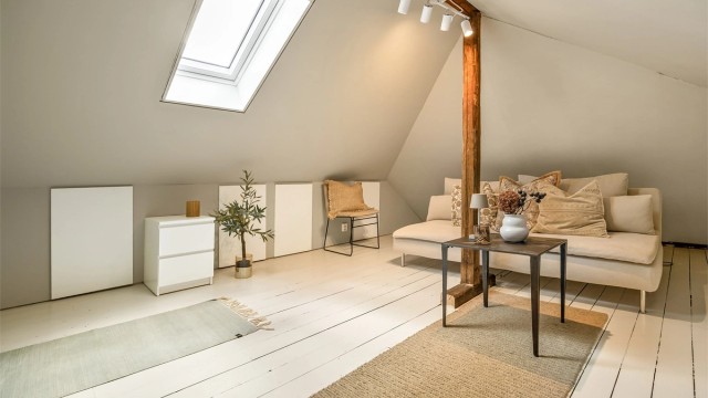 Innredet loftstue med takvindu, hvitmalt tregulv og oppbevaring i kneloft. Rommet er ikke godkjent for varig opphold.