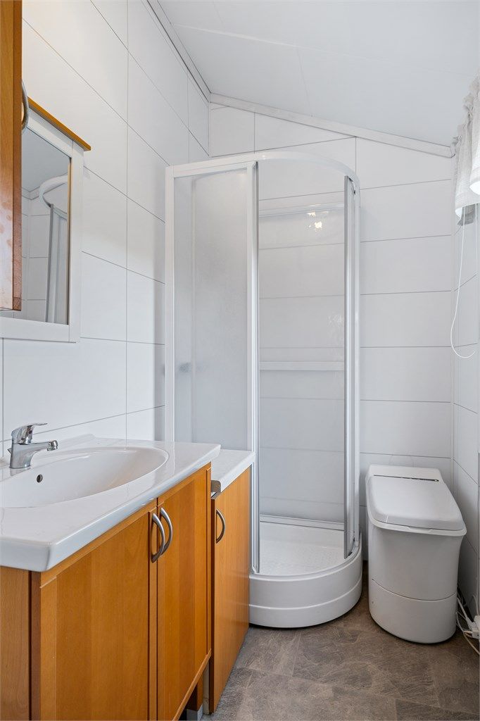 Badet i hovedhytta er utstyrt med servant, forbrenningstoalett og dusjkabinett.