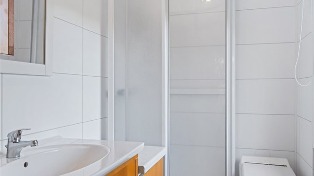 Badet i hovedhytta er utstyrt med servant, forbrenningstoalett og dusjkabinett.