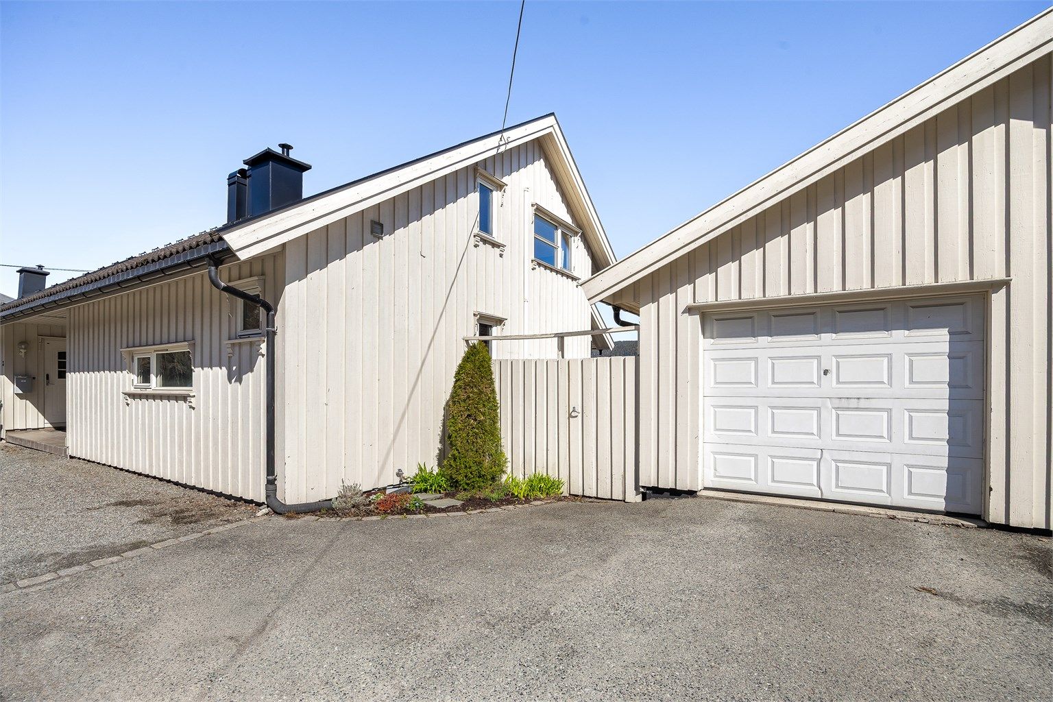 Til boligen hører en halvpart av en vertikaldelt garasje med asfaltert oppkjørsel.