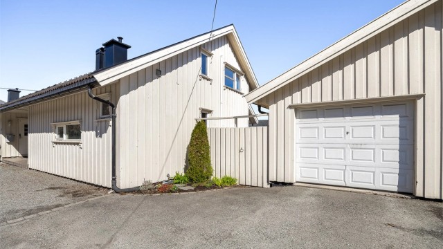 Til boligen hører en halvpart av en vertikaldelt garasje med asfaltert oppkjørsel.